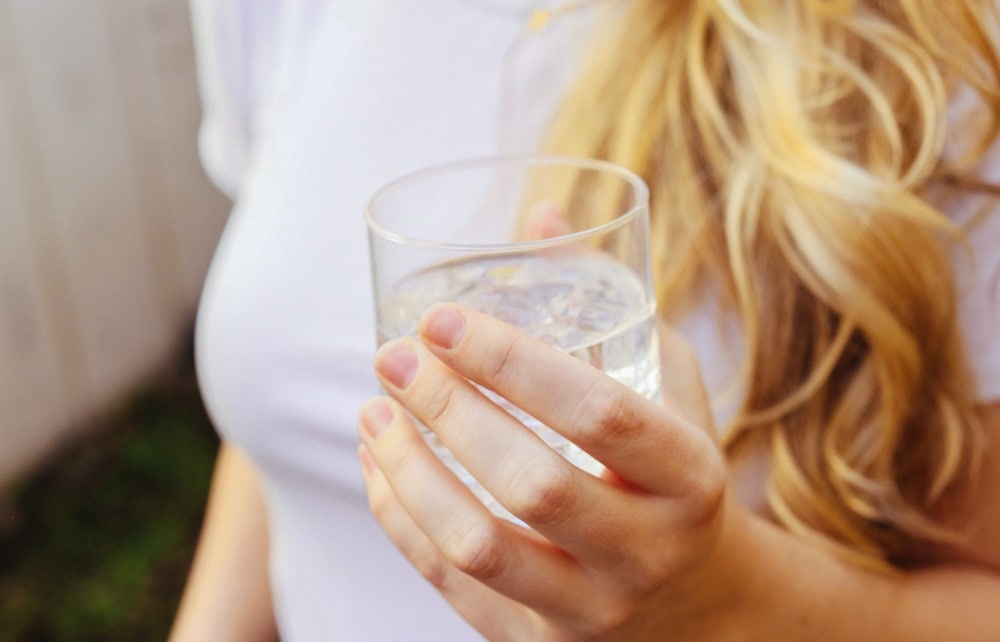 Verre d'eau dans la main d'une femme